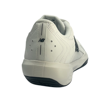 Back view of a New Balance men's court shoe. Suitable for tennis, pickleball and netball. Has a white mesh upper with a black sole.