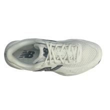 Top view of a New Balance men's court shoe. Suitable for tennis, pickleball and netball. Has a white mesh upper with a black sole.