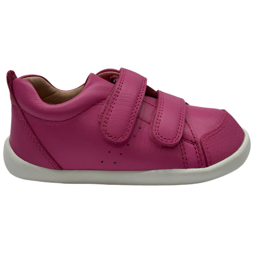 Pink children's shoe with velcro straps on a white background