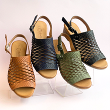 Cabello Alaca. Four women's open-toe slingback sandals with a woven lattice upper design. The sandals are shown in four colors: tan, navy blue, sage green, and black, all with tan soles.