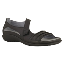 The Noat Papaki. A women's open-toe slip-on sandal in black, featuring a textured black wedge sole and a wide adjustable strap with a velcro closure. Mae with a cork and latex removable insole.